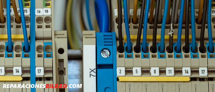 Electricista profesional de reparacionesbilbao.com revisando un cuadro eléctrico de mando y protección